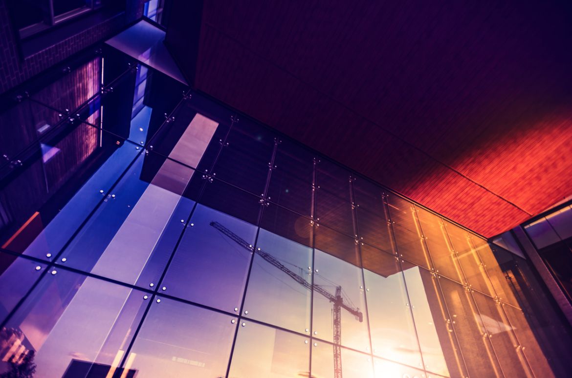 Construction crane in purple reflection window
