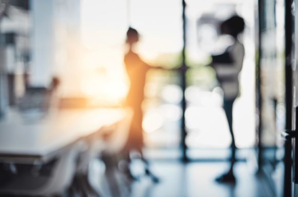 Business women shaking hands in office blurred