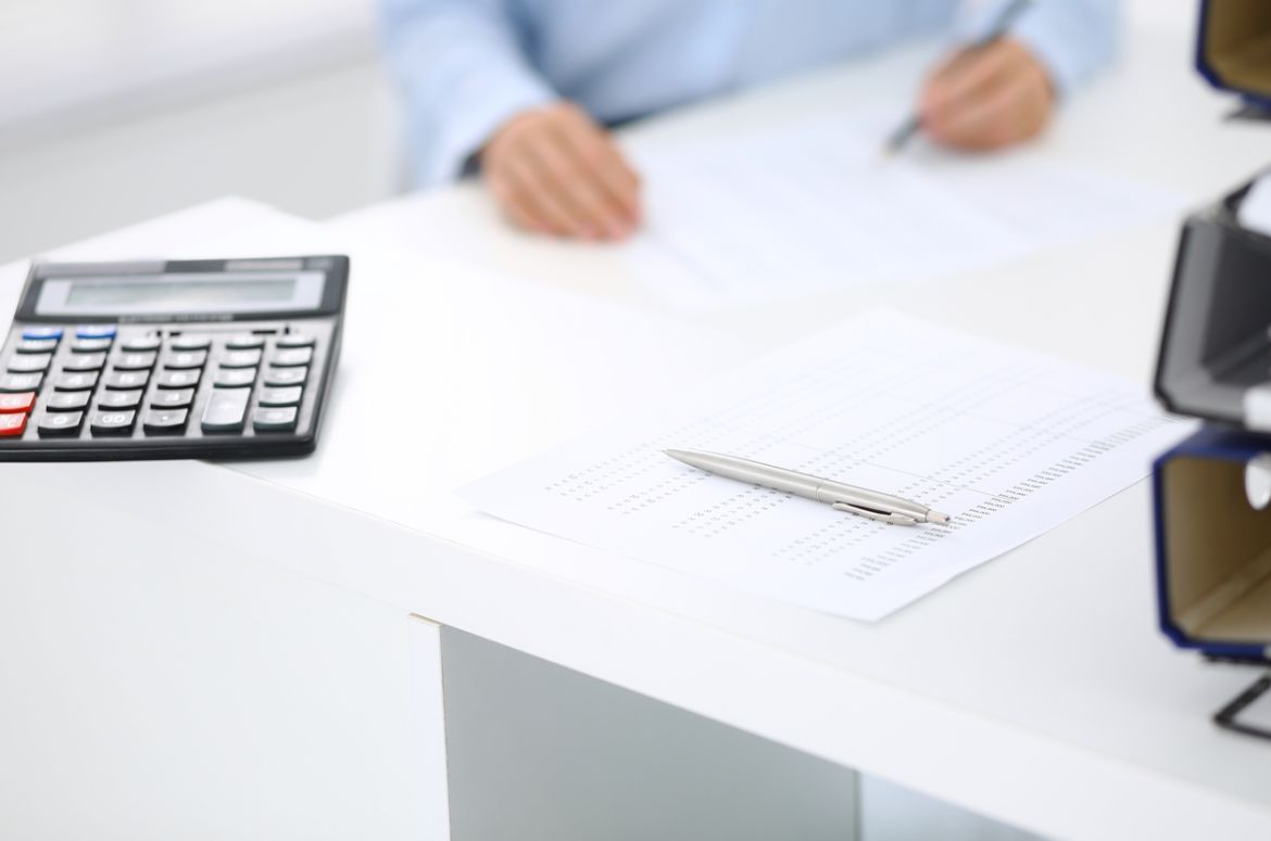 Calculator and financial papers with bookkeeper