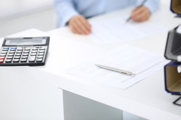 Calculator and financial papers with bookkeeper