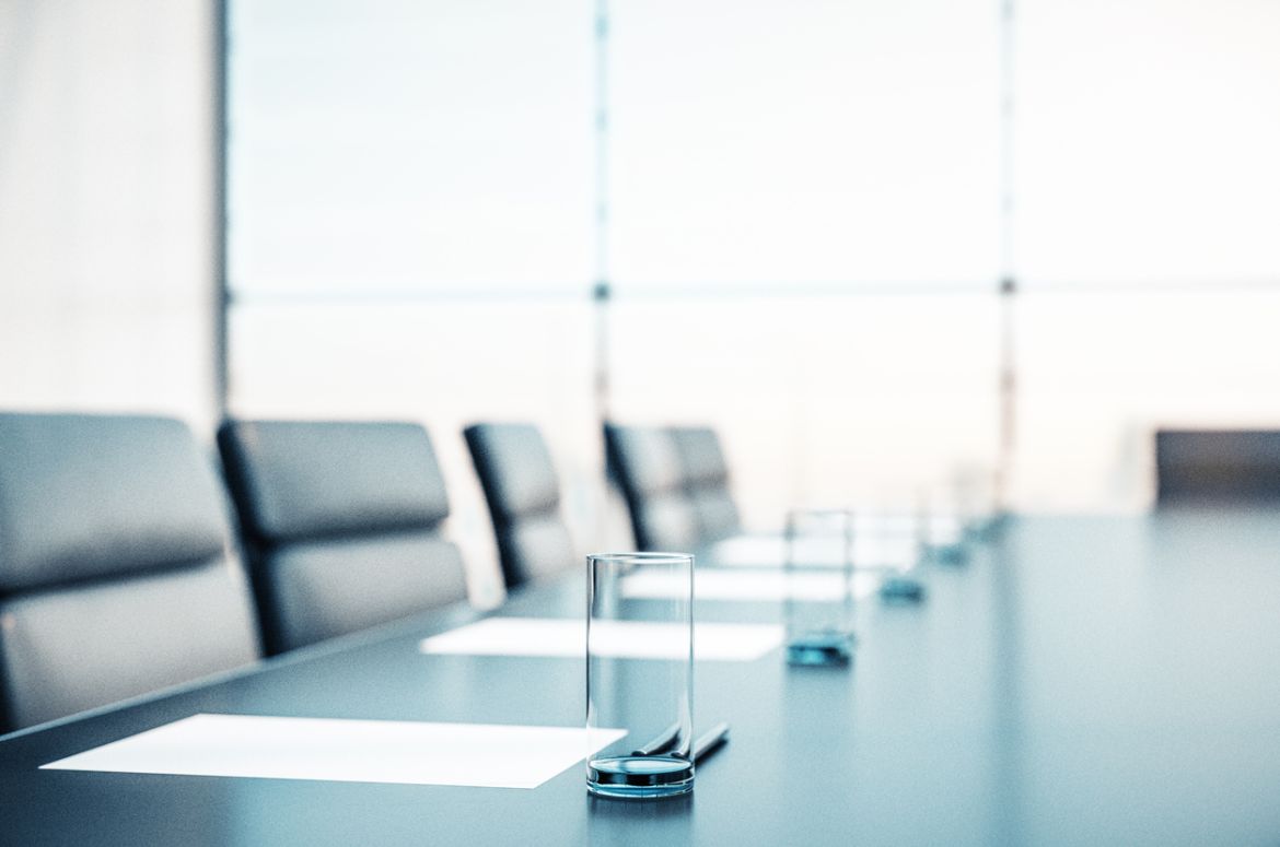 conference room with water, papers, armchairs and a large window