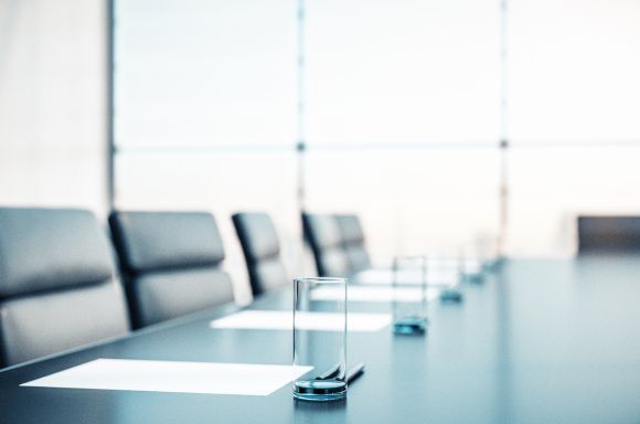 conference room with water, papers, armchairs and a large window