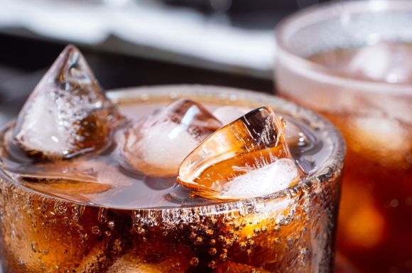 Cola with crushed ice in glass and there is water droplets around