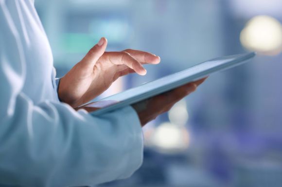 Doctor, researcher or scientist browsing the internet on a tablet for information