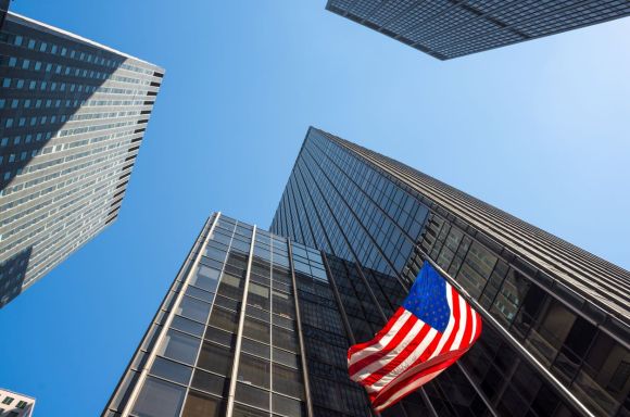 Skyscrapers and an American flag waving in mid town Manhattan