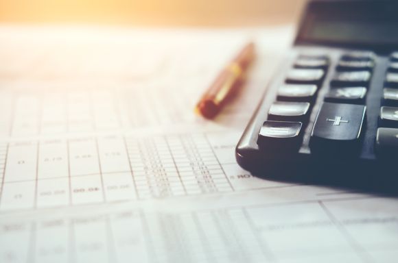 calculator and pen on financial documents